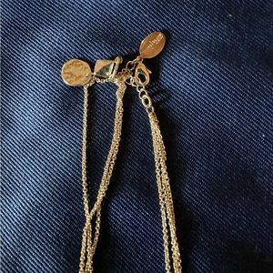 Triple strand silver necklace with varying sized discs.